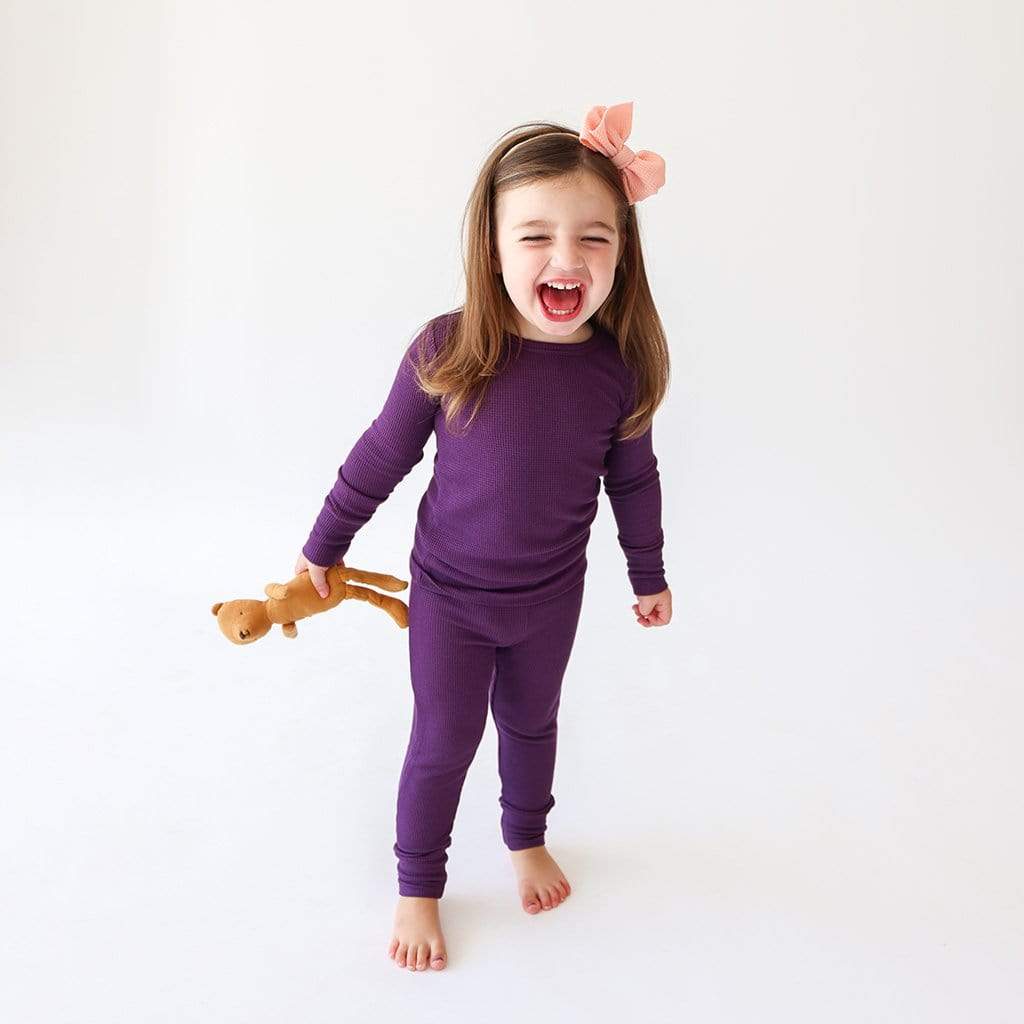 Little girl screaming with excitement in purple waffle pajamas