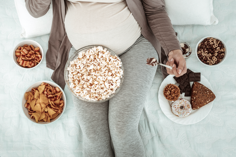 A Woman Sitting and Eating with Pregnancy Cravings 