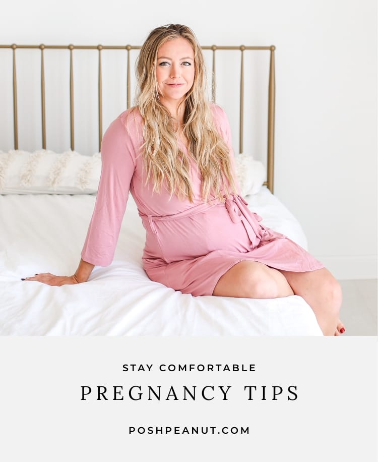 Pregnant woman in pink robe sitting on bed