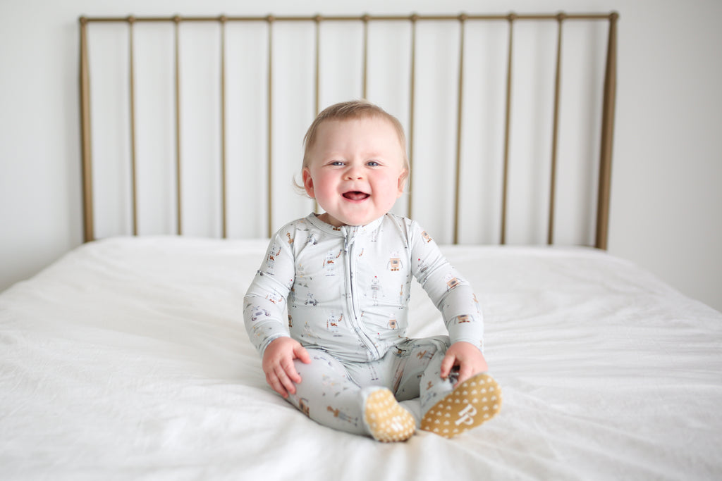 baby boy wearing zipper pajamas on bed