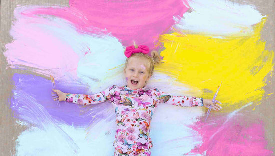 girl laying on rainbow paint  