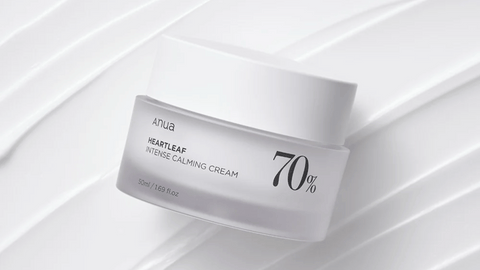 A jar of Anua's "Heartleaf Intense Calming Cream" with 70% indicated, placed on a white ribbed surface.