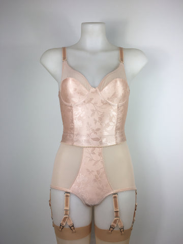 faux vintage inspired longline girdle and front fastening bralette in peachy floral satin fabric. Longline girdle has 6 beige suspender clips holding up seamed nylon stockings. Matching garter belt, longline underwired bra and pantie girdle 