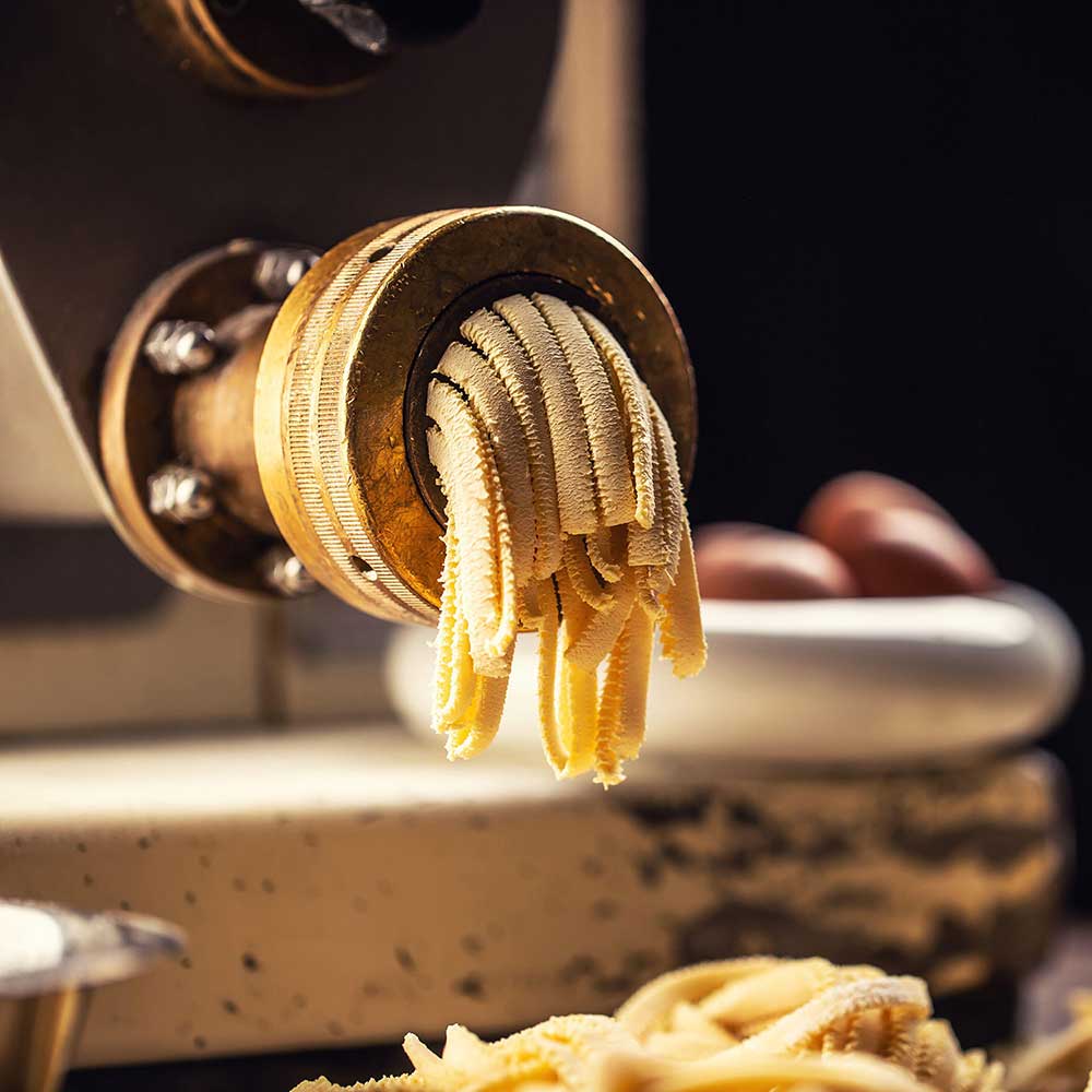 Fresh fettuccine pasta extruded through a bronze die.