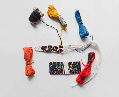 Colourful stranded cotton embroidery floss being tied into a friendship bracelet