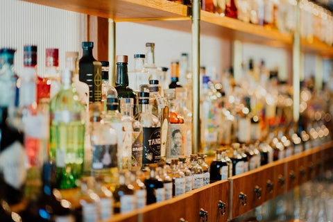 alcoholic beverages along a bar shelf