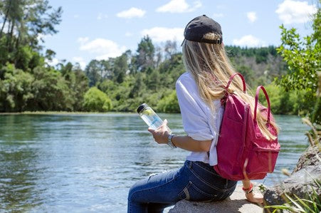 woman drinking a bottle of water in nature