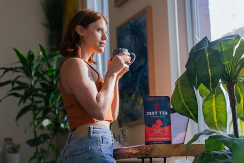 woman holding mug of cinnamon apple tea