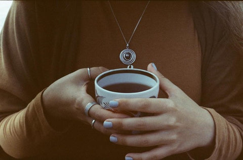woman holding cup of black tea