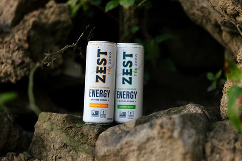 two cans of zest tea on a rocky ledge