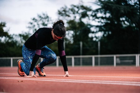 woman about to start running on a track