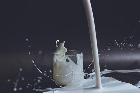 milk spilling out of a glass