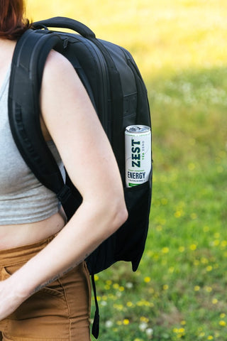 woman hiking with zest sparkling energy tea in her backpack