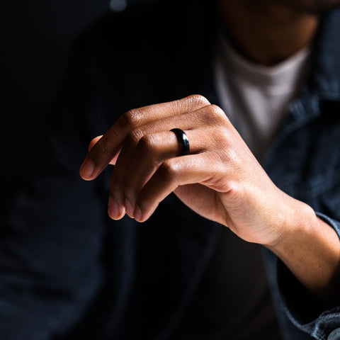 man holding hand with a black tungsten ring on it