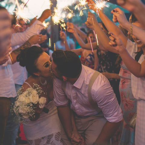 bride and groom kissing under sparklers