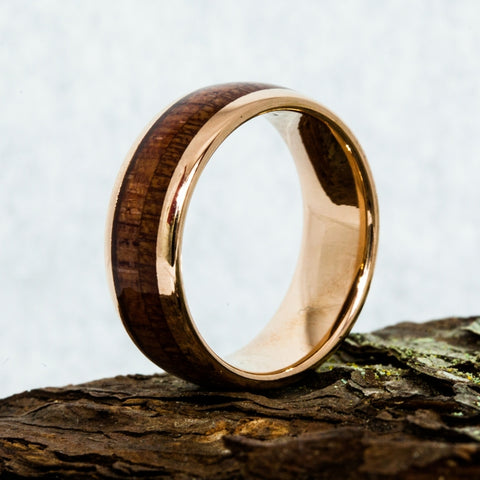 wood inlay tungsten ring laying on a rock