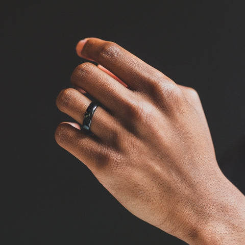 mans hand with black wedding band