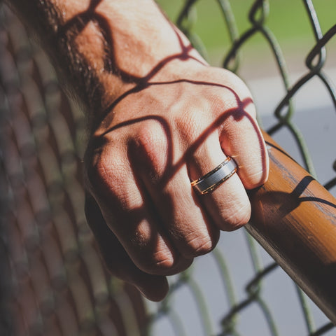 tungsten wedding band on mans hand on railing