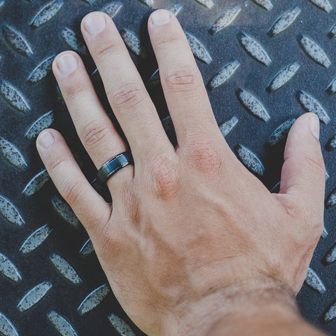 mens hand with wedding band on background