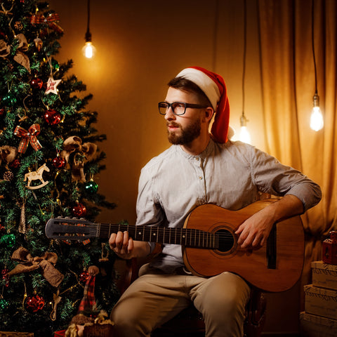 man holding guitar with glasses in a santa hat