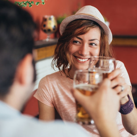 woman smiling while drinking a beer