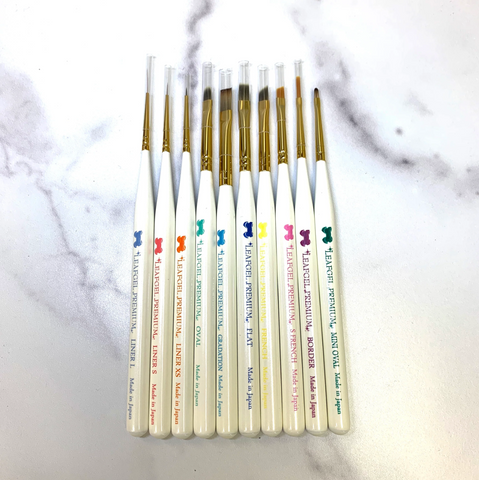 Ten nail tech brushes, each with different tips and colored words on them. All of them say Leafgel.