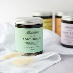 A jar of body scrub sat on a white towel