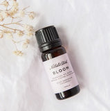 A bottle of essential oil with a flower