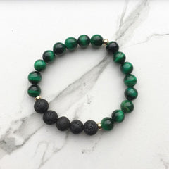 A green tigers eye bracelet on a white marble background