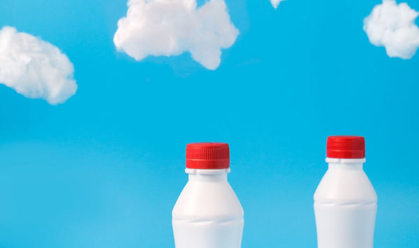 Two white plastic bottles on a cloudy background