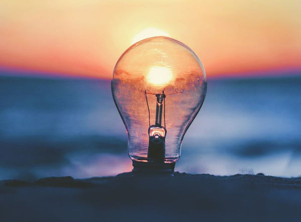 The sun shining through a lightbulb on the beach