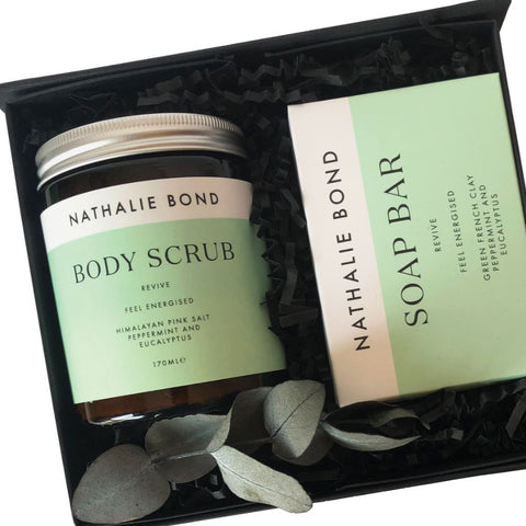A jar of revive bath salts and a soap bar in a black gift box