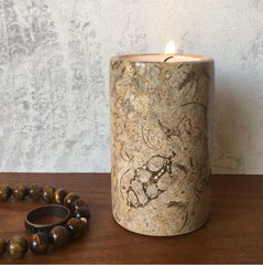 A fossil stone candle holder on a bedside table