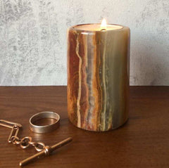 A solid Onyx stone candle on a chest of drawers