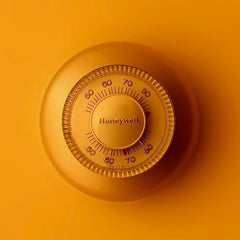 A thermostat on an orange wall