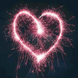A pink heart written in the air with a sparkler