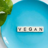 A blue plate with the word VEGAN written on it