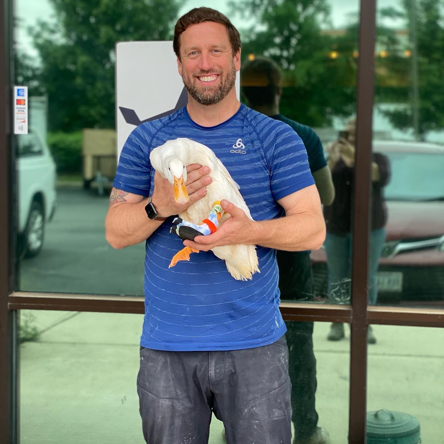 Derrick Campana with a duck wearing animal prosthetics.