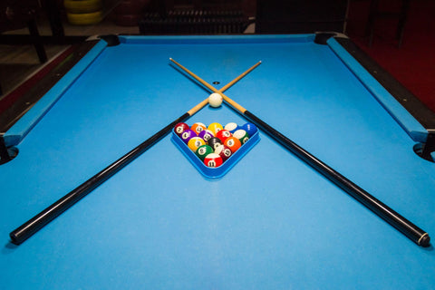 Billiards balls and cue on billiards table