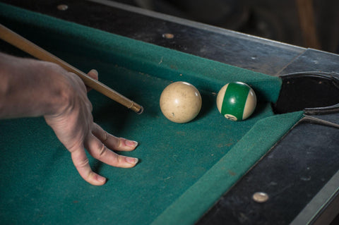 Billiards balls and cue on billiards table.