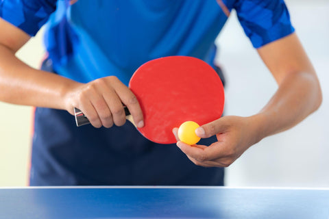 Close up of person serving in ping pong match.