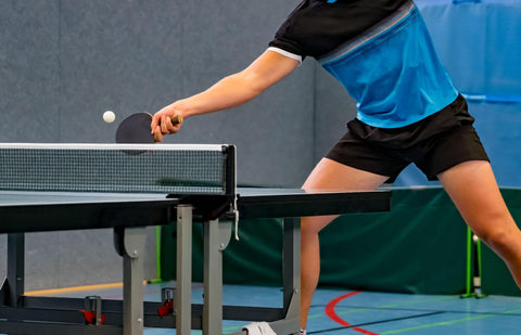 Close up of ping pong players legs.