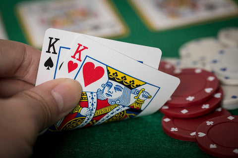 Closeup of hands with two kings, playing Texas Hold'em Poker and gambling.