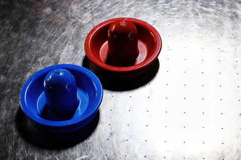 Red and blue air hockey paddles.