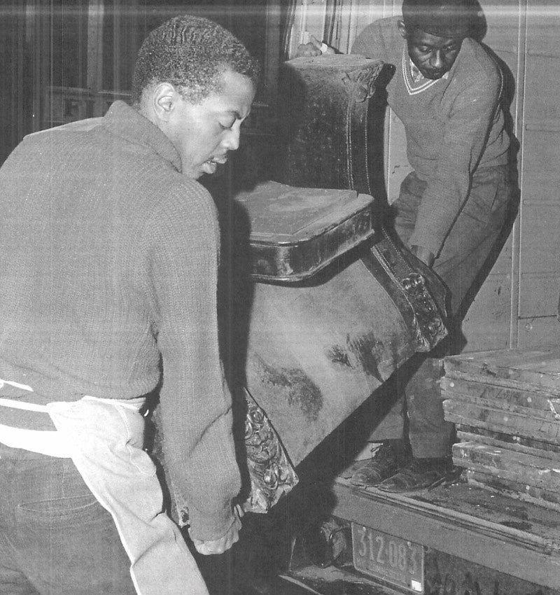 old black & white photo of men carrying pool table