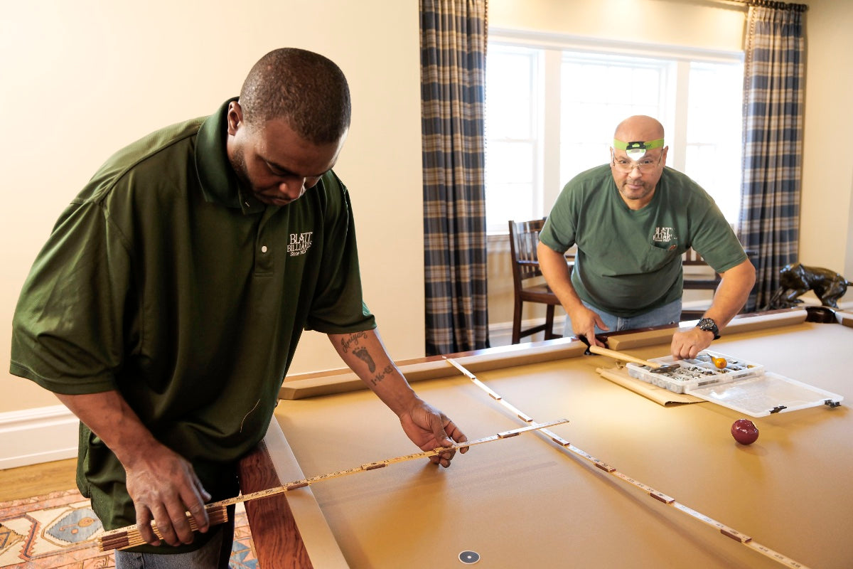 men measuring pool table