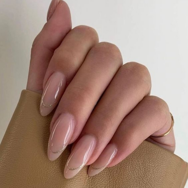 neutral almond nails with gold french tip outline