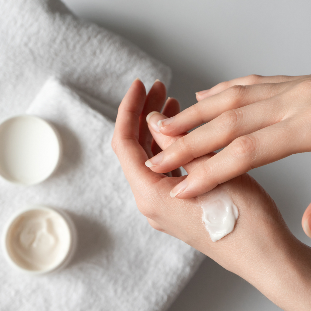 women moisturizing hands with hand cream