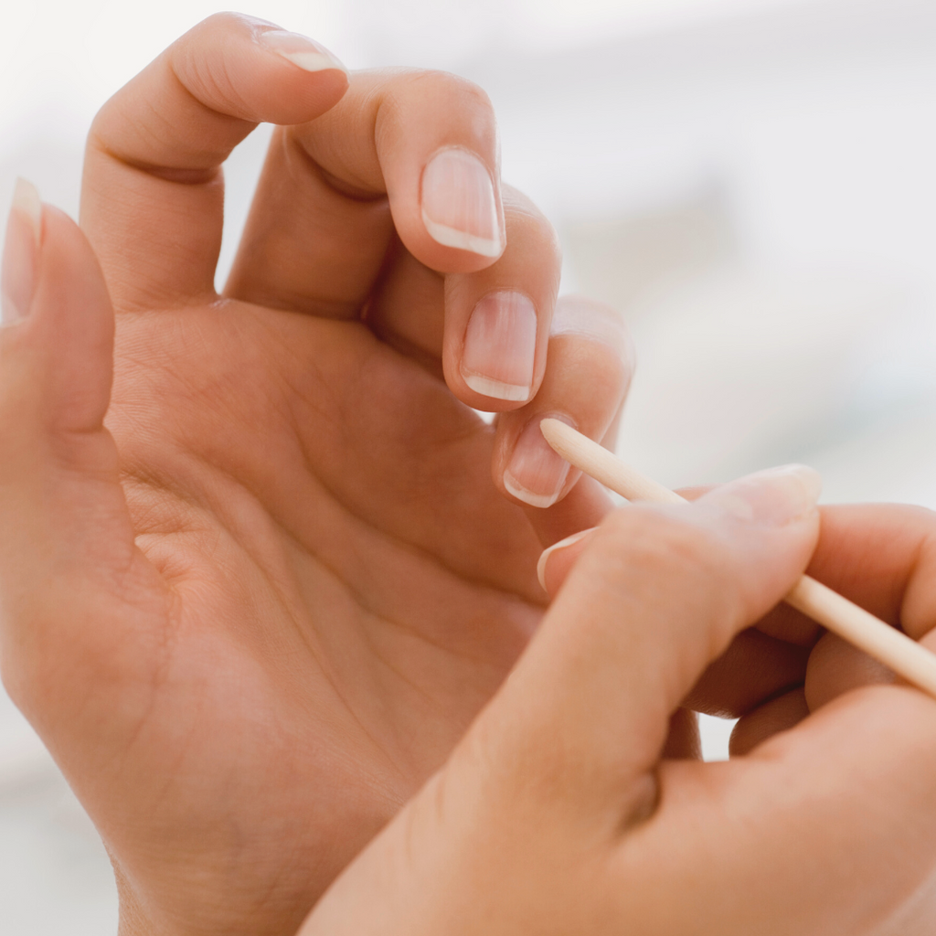 pushing back cuticles with manicure stick