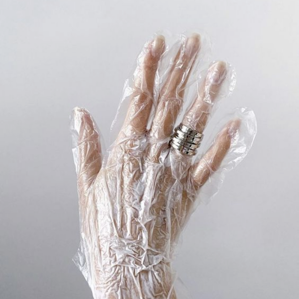 hand with clear glove on hand mask treatment